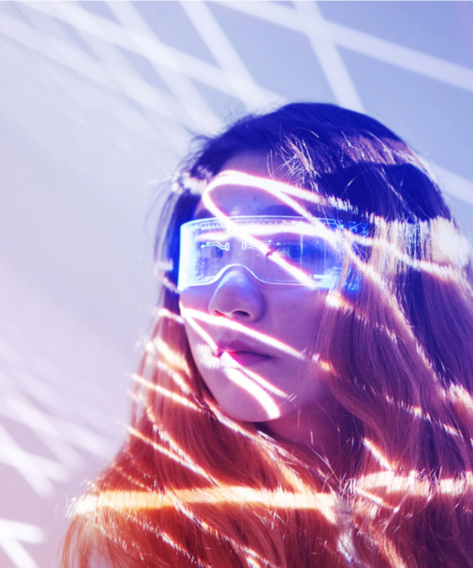 Woman wearing futuristic glasses with light patterns projected on her face, representing innovation at GFT.