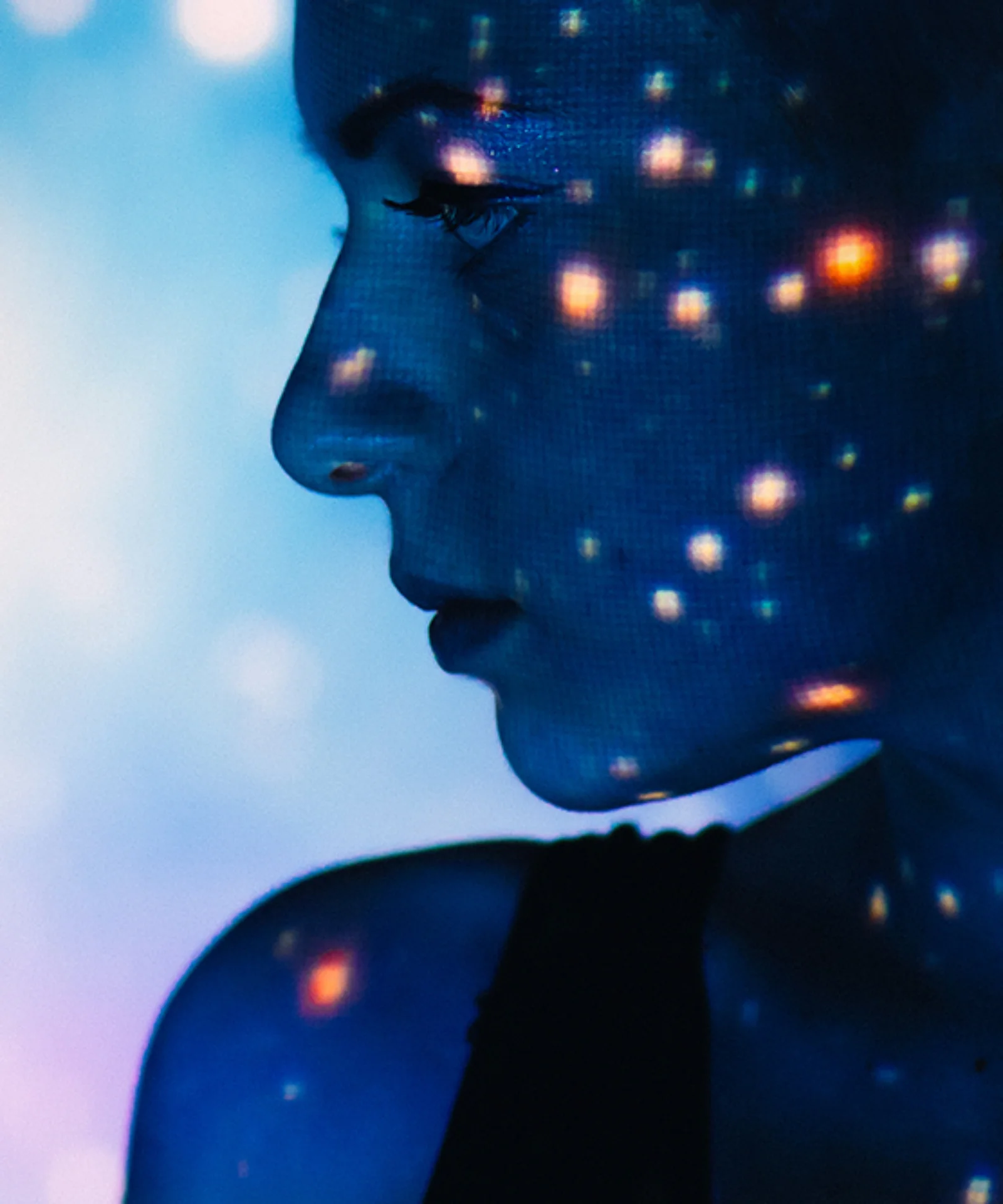 Silhouette of a woman with digital lights projected on her face, set against a vibrant, futuristic background.