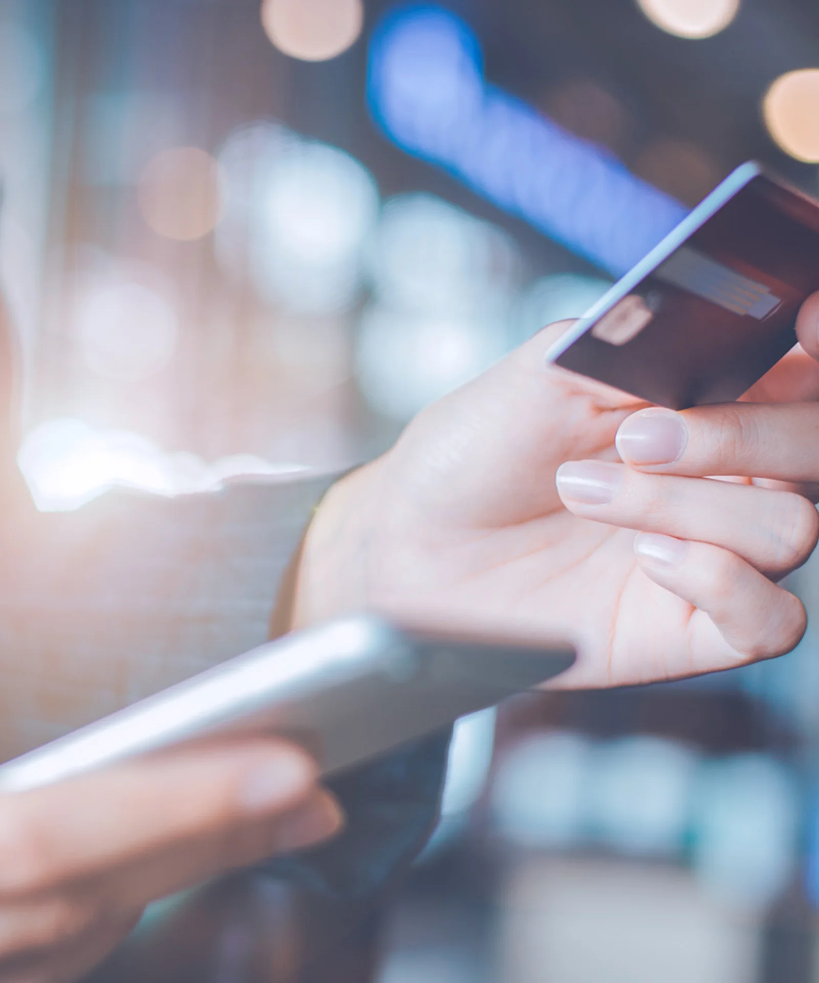 Close-up of a person holding a smartphone and credit card, highlighting the ease and convenience of digital payments.