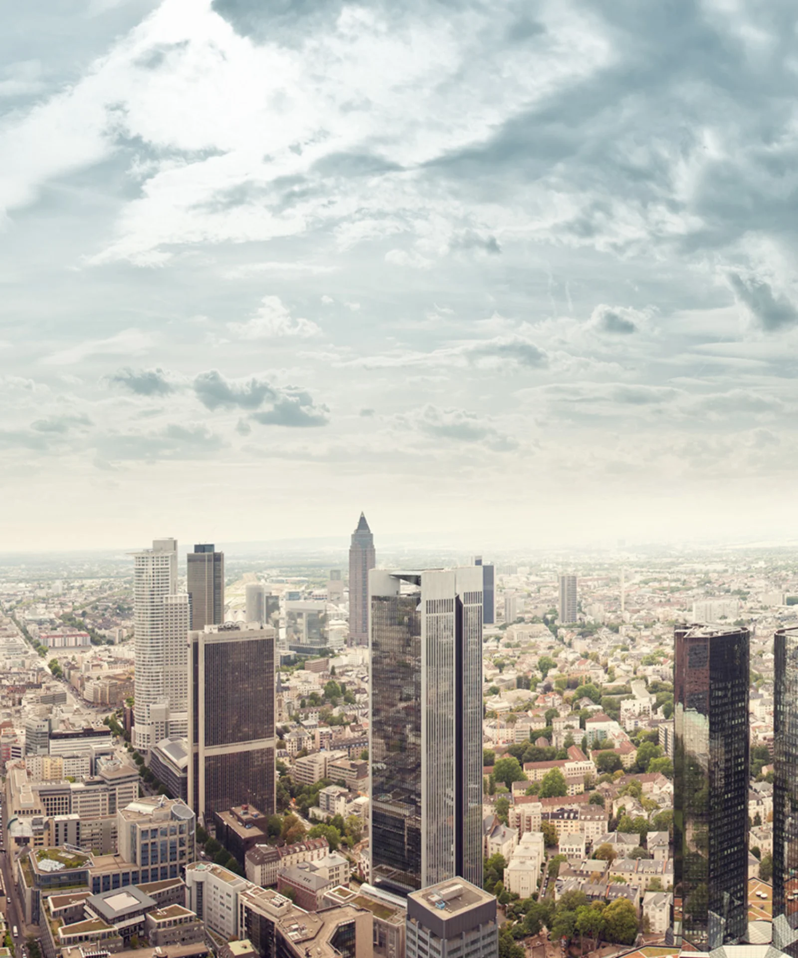 Ein Panoramablick auf die Skyline einer modernen Stadt mit hoch aufragenden Gebäuden, die den Replatforming-Prozess der DekaBank mit GFT darstellen.