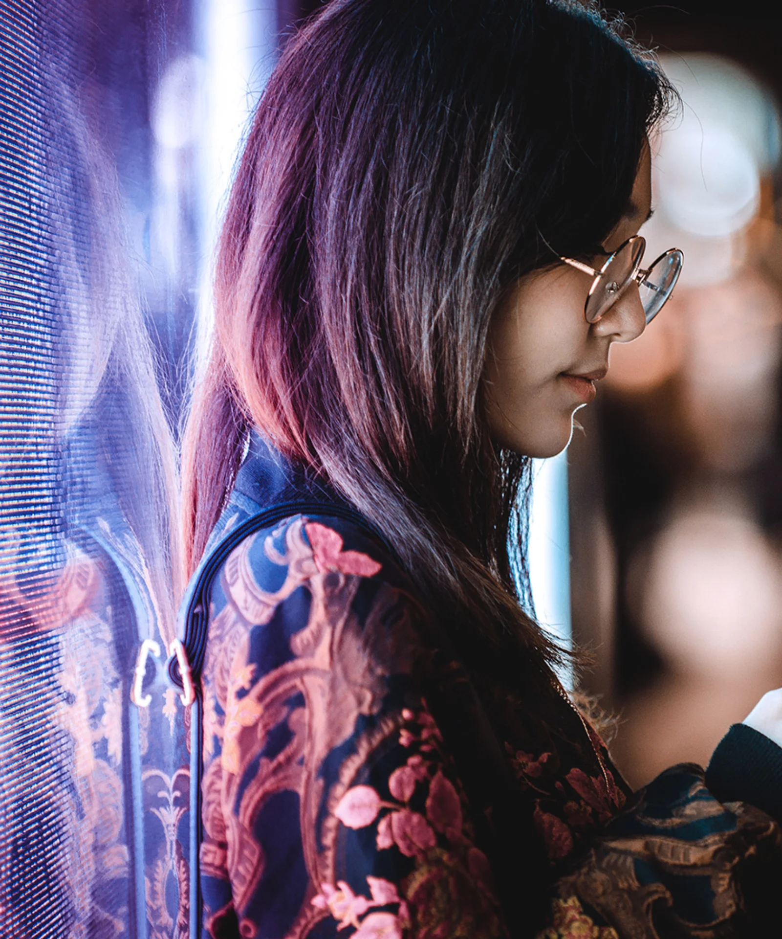 A young woman using her smartphone in a vibrant, urban setting, symbolising the future of personal banking through digital innovation.