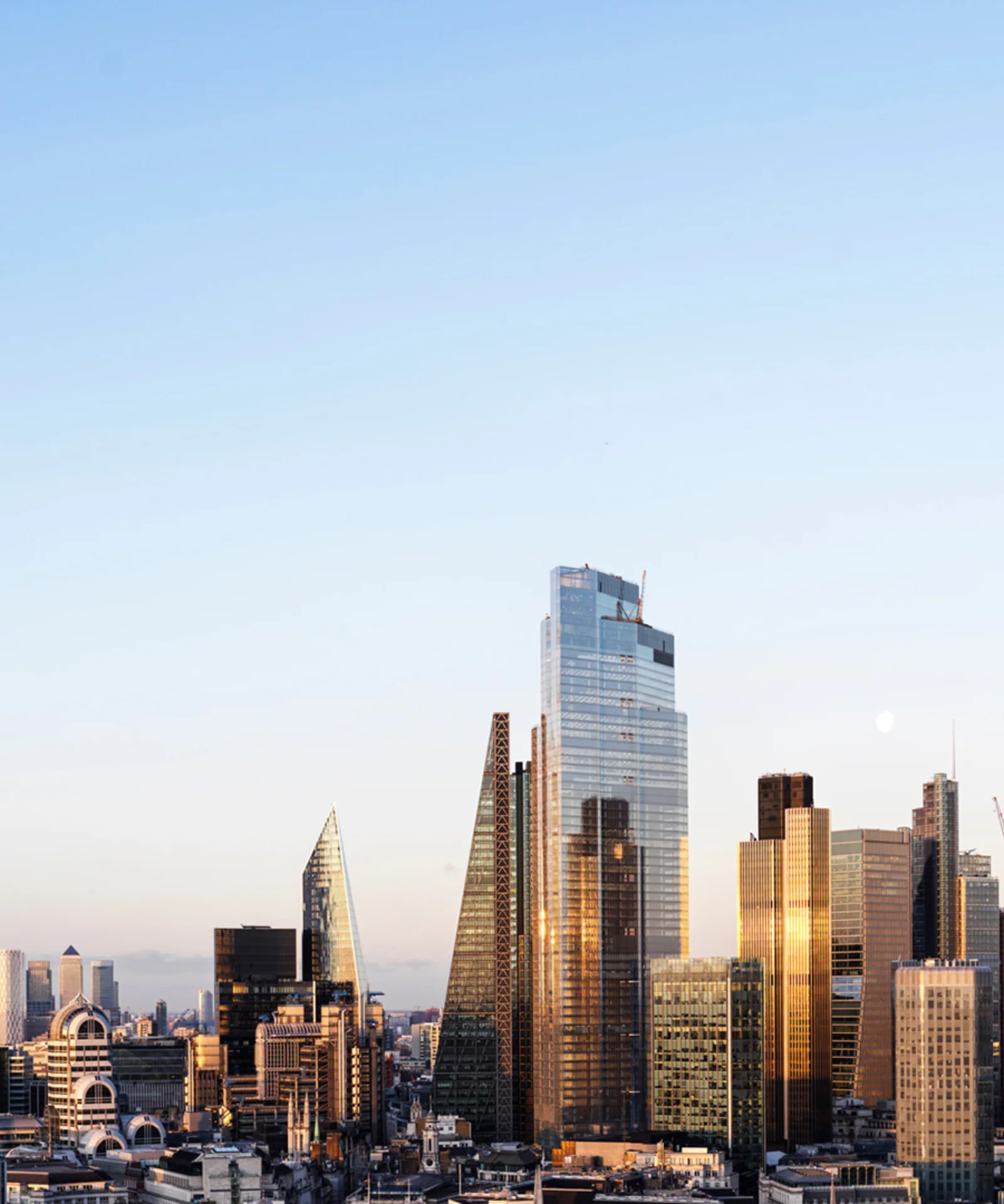 Skyline of modern skyscrapers at sunset with clear skies.