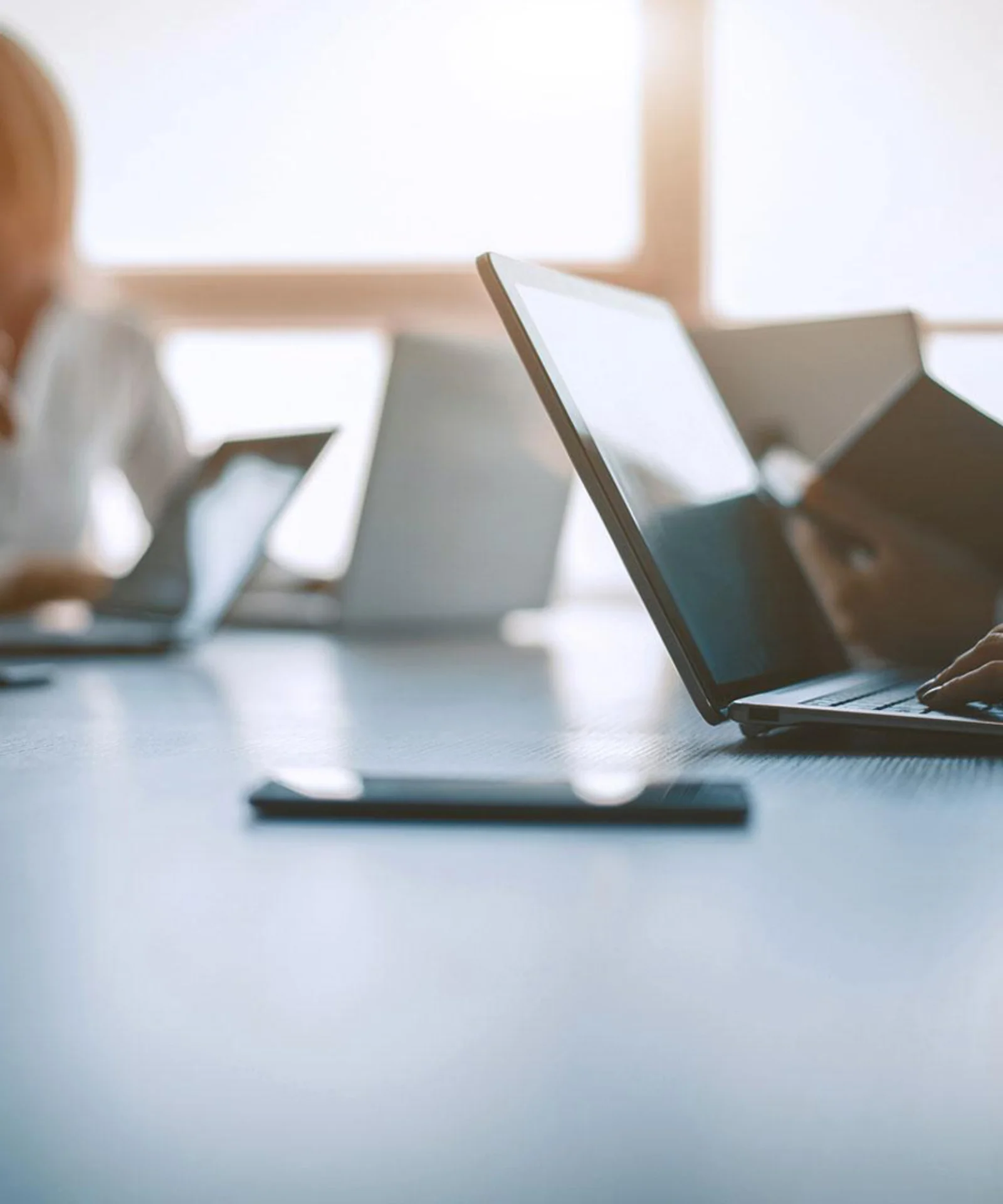 Business professionals working on laptops in a meeting room, focusing on secure and connected AWS cloud solutions.