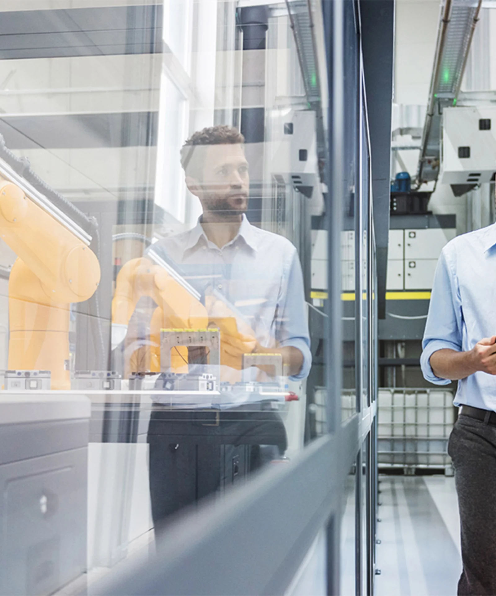 Cette image capture l&#039;environnement innovant d&#039;une usine intelligente, mettant en vedette un ingénieur professionnel avec une tablette se promenant dans une usine de fabrication de haute technologie. L&#039;arrière-plan présente des bras robotisés avancés fonctionnant derrière des cloisons en verre, symbolisant l&#039;automatisation et la précision dans les processus de fabrication modernes. La scène met en évidence l&#039;intégration de la technologie numérique et de l&#039;automatisation dans la chaîne de production, reflétant les avancées de l&#039;industrie 4.0. La présence de l&#039;ingénieur avec une tablette souligne le rôle de la surveillance humaine et l&#039;utilisation d&#039;outils numériques dans la gestion et l&#039;optimisation des opérations de l&#039;usine.