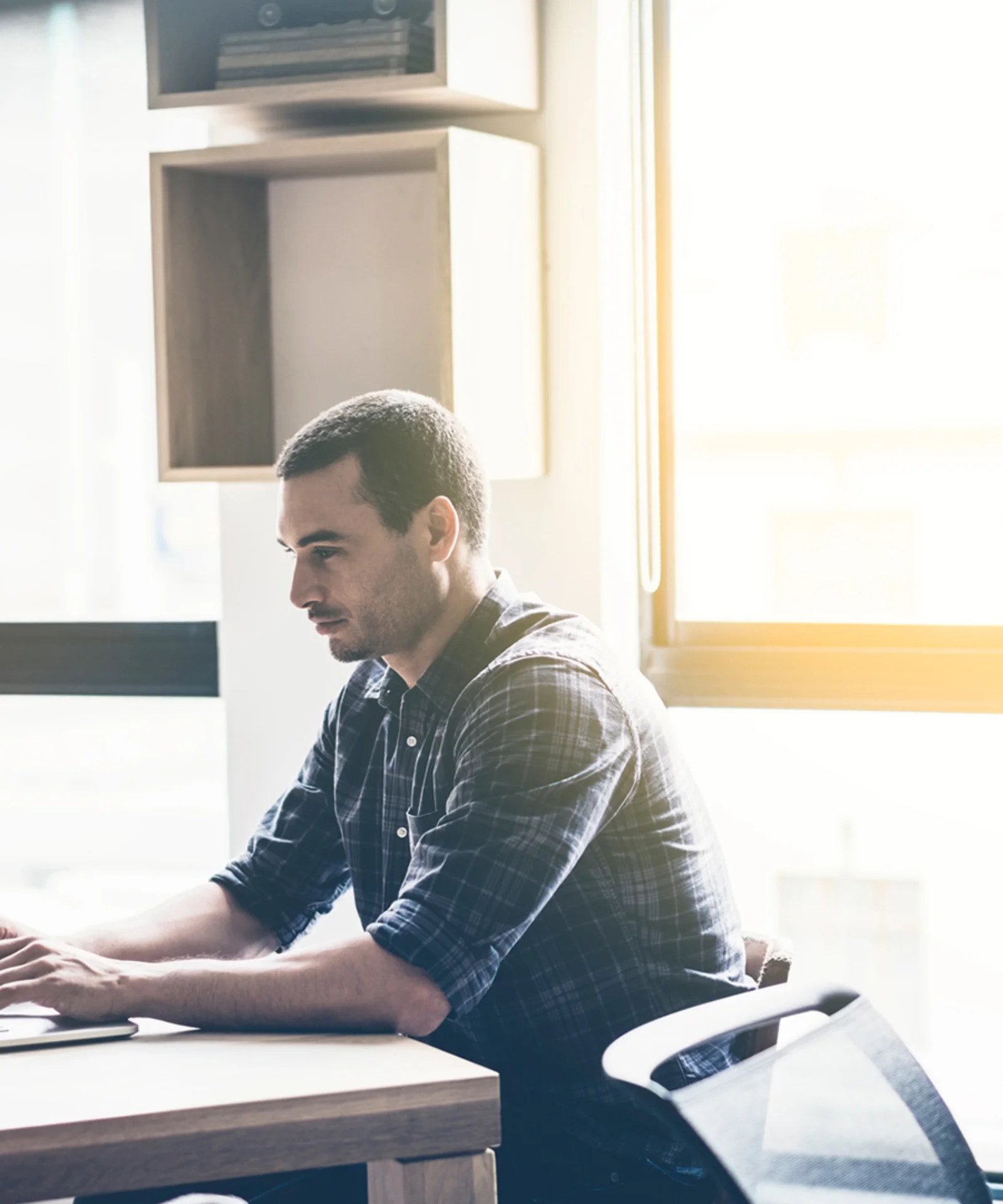 A man working on a laptop in a bright office setting, representing the redefinition of digital rights management in the modern era.