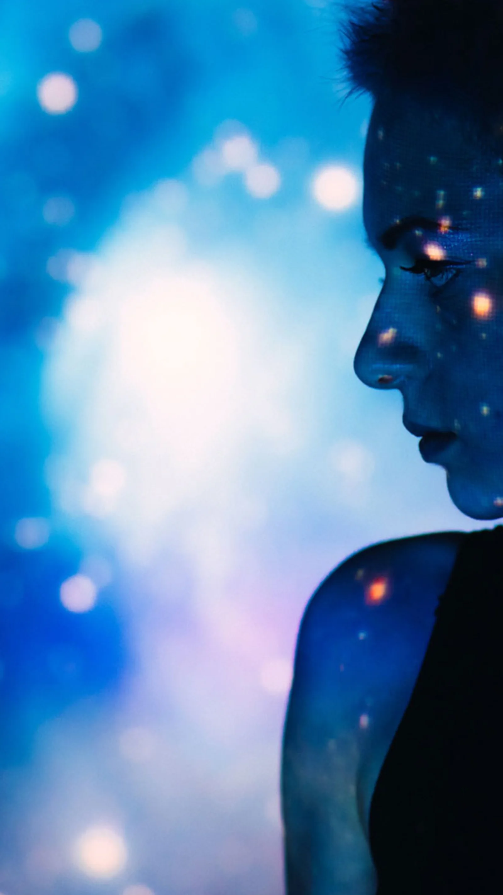 A silhouetted profile of a person with a digital starry projection on their face and background, symbolising the power and creativity of artificial intelligence.