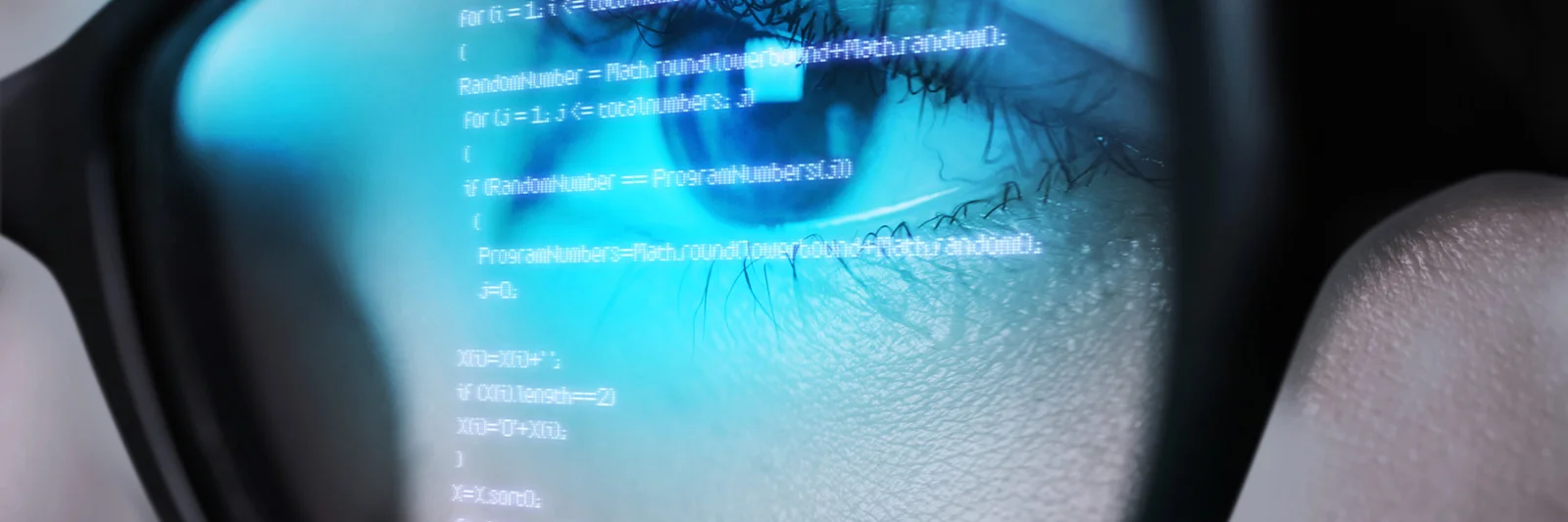 Close-up of a person&#039;s eye reflecting code on a screen, symbolizing in-depth analysis and focus in software development.