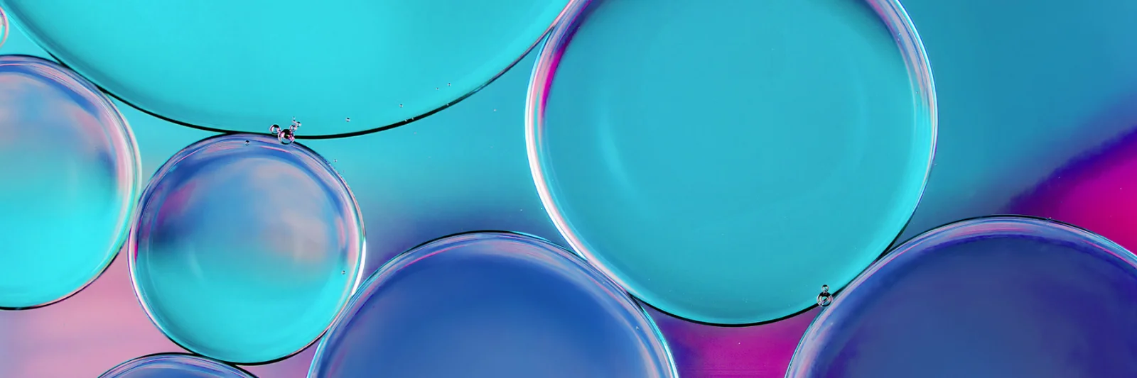 Abstract image of various-sized blue and purple bubbles overlapping each other