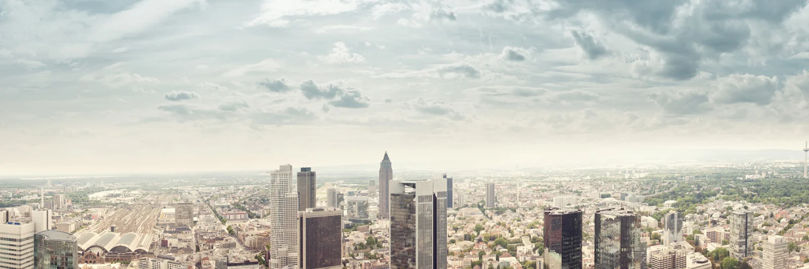 Uma vista panorâmica do horizonte de uma cidade moderna com edifícios imponentes, representando a jornada de reformulação do DekaBank com a GFT.