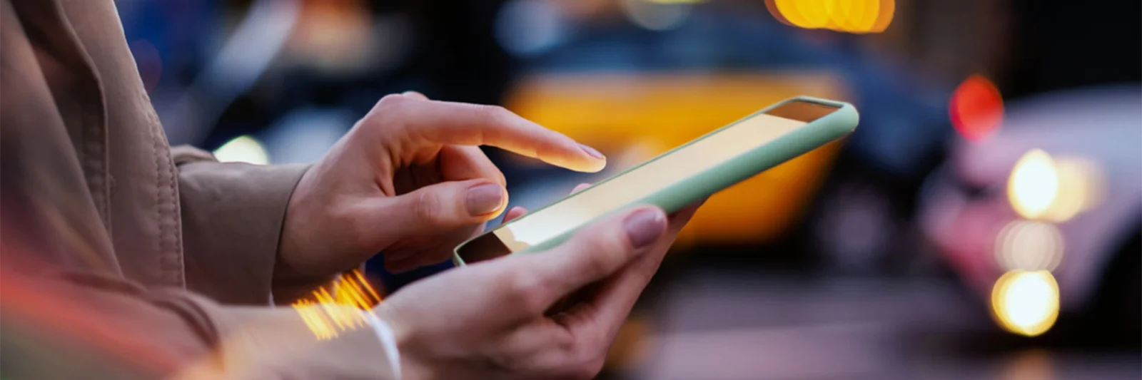 Close-up of a person using a mobile device on a busy city street, symbolising the modernisation efforts of a global bank to enhance digital banking services.