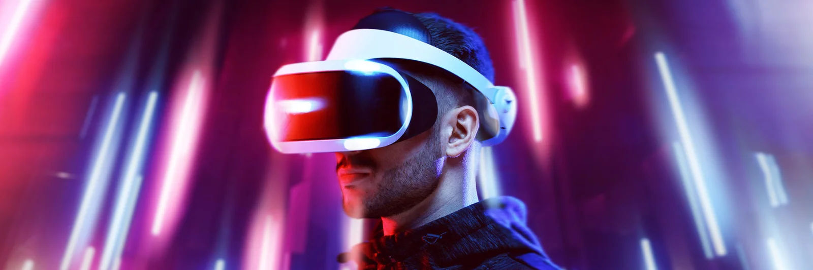 A person wearing a VR headset, illuminated by vibrant, colourful lights, representing the cutting-edge of immersive technology.