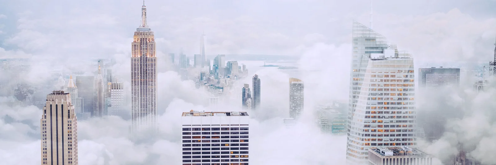 A breathtaking view of skyscrapers towering above the clouds in a misty cityscape, symbolising innovation and modern architecture.