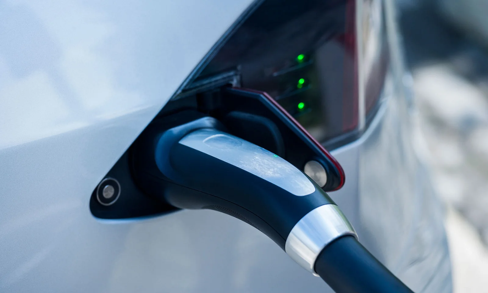 Close-up of an electric vehicle being charged at a charging station.