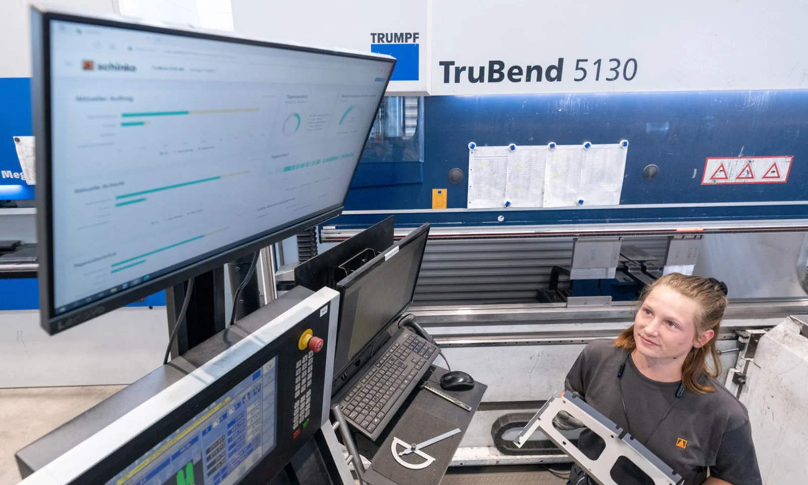 A worker at Schinko reviews real-time data on a TruBend 5130 machine, showcasing enhanced transparency and efficiency in manufacturing operations.