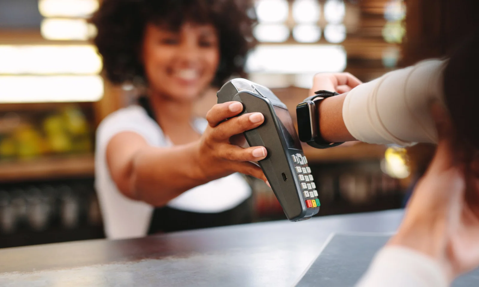 Customer making a payment using a smartwatch at a retail counter