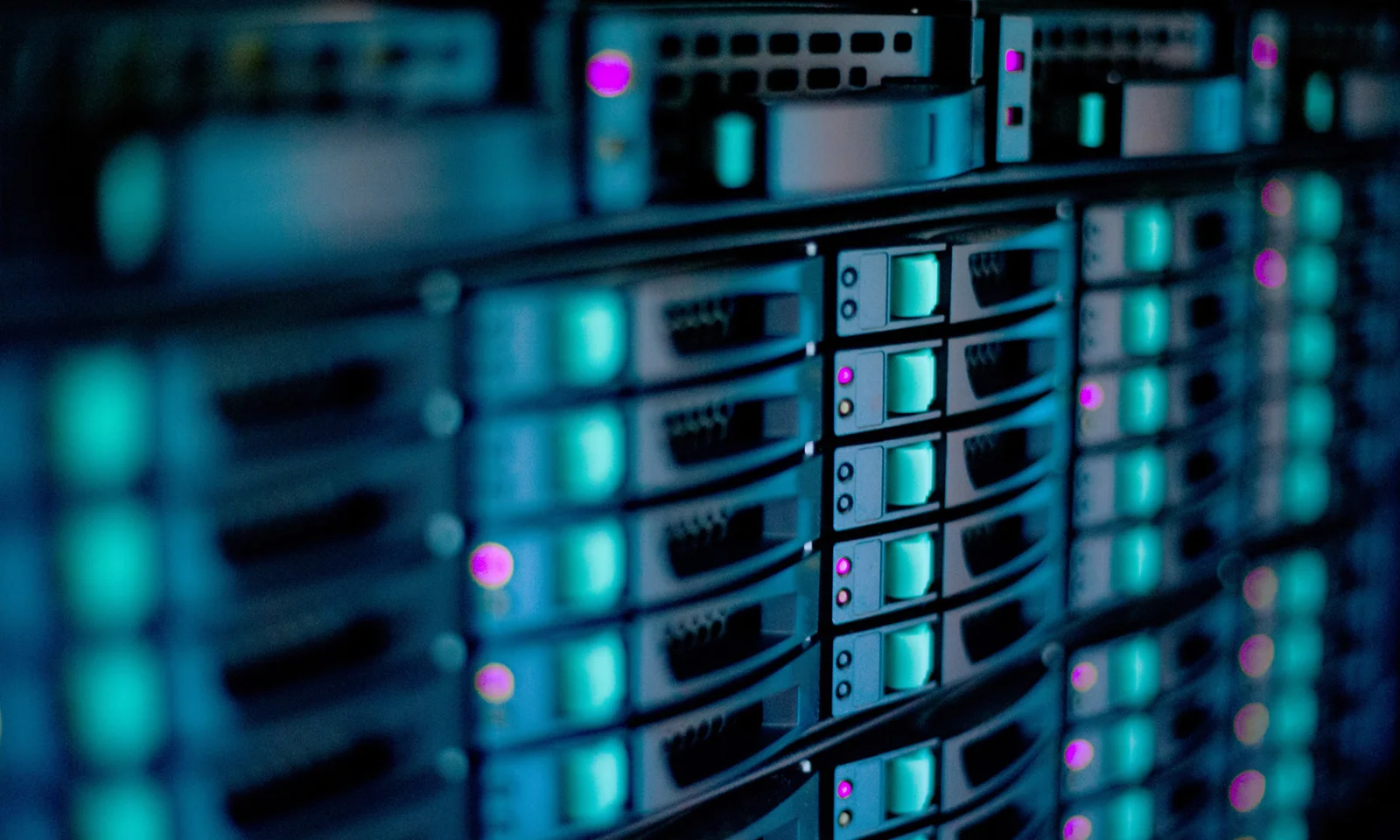 Close-up of data servers with glowing blue and purple lights, representing the cloud migration of Portal de Documentos for enhanced performance and scalability.