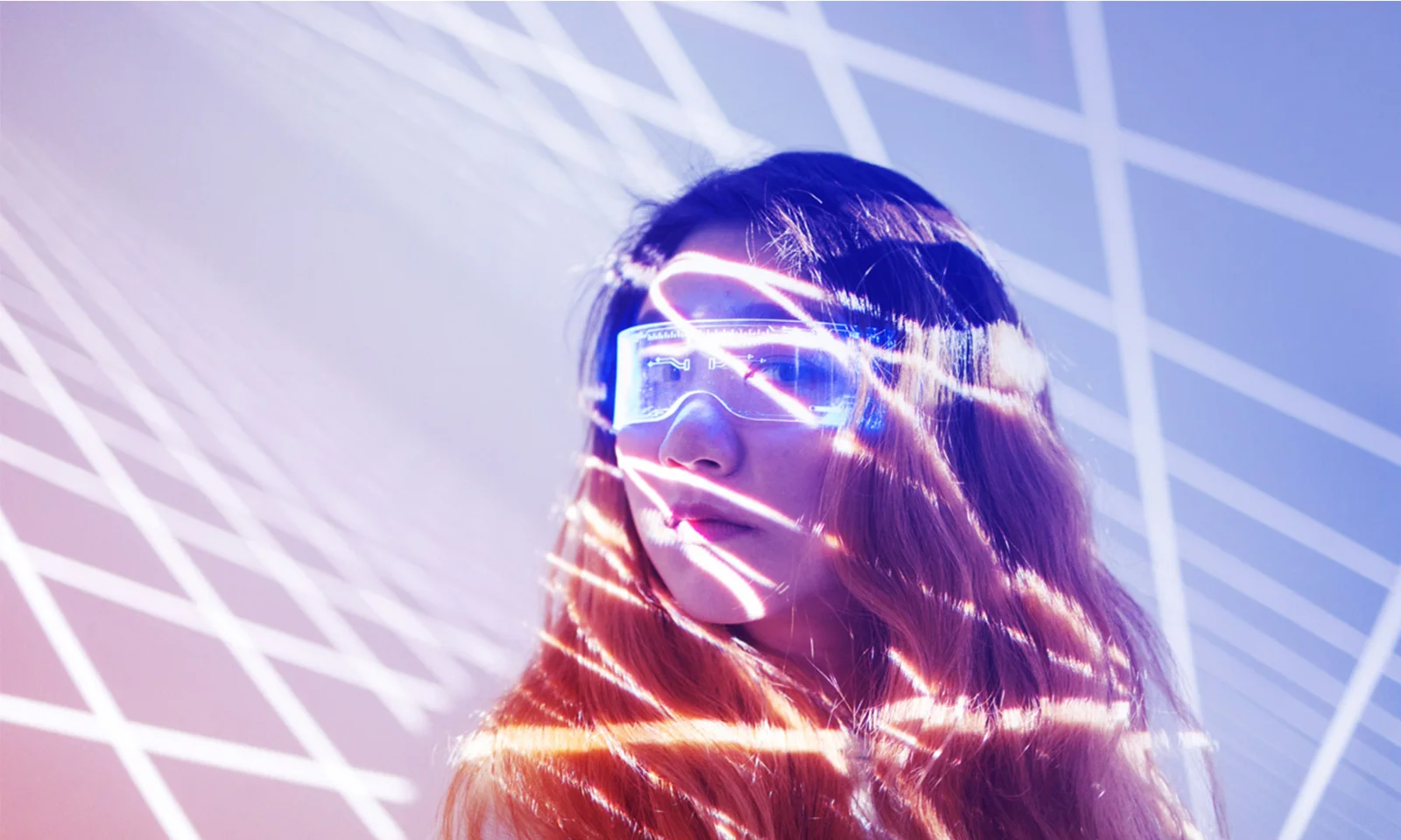 Woman wearing futuristic glasses with light patterns projected on her face, representing innovation at GFT.