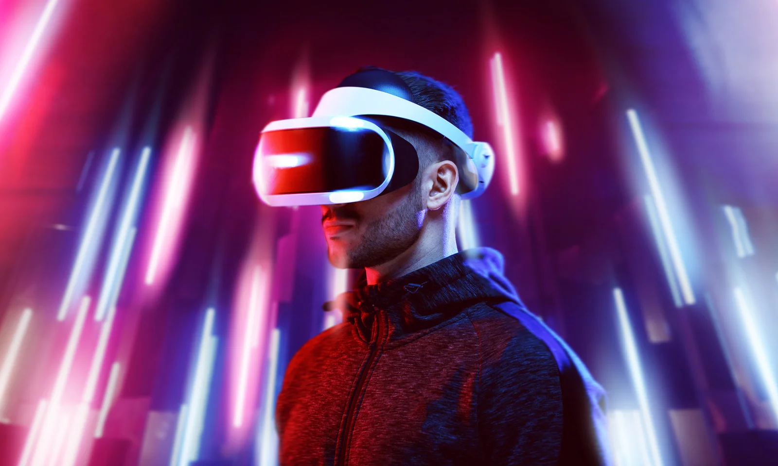 A person wearing a VR headset, illuminated by vibrant, colourful lights, representing the cutting-edge of immersive technology.