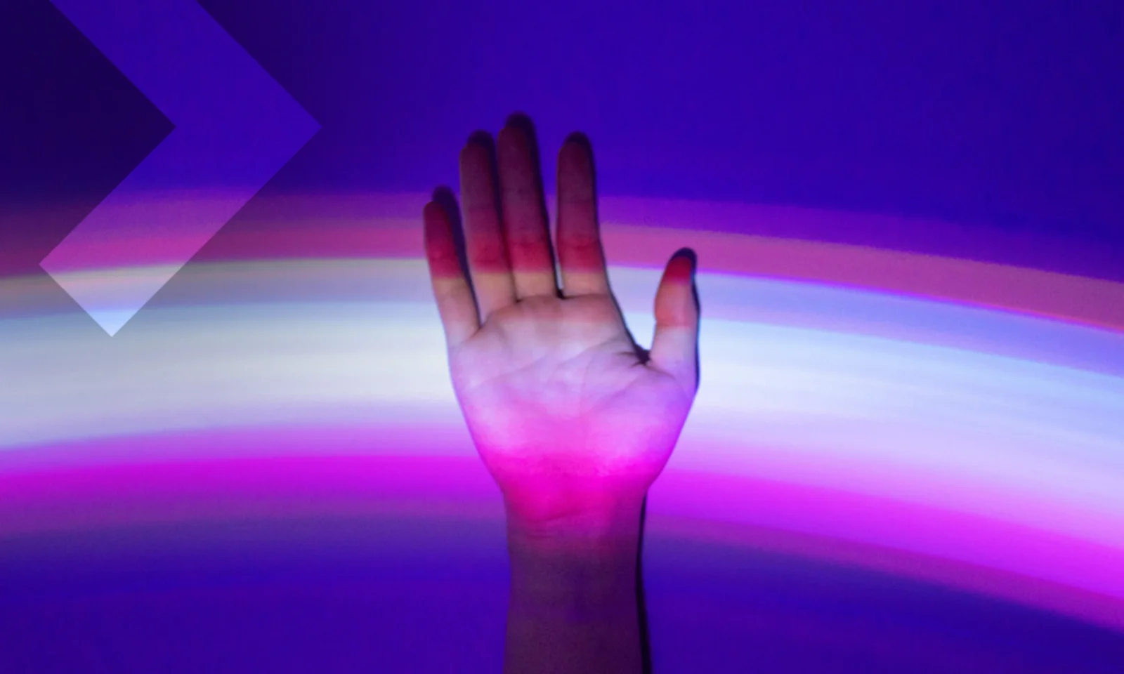 Hand raised against a background of colorful light streaks, symbolizing the connection between human interaction and digital technology.