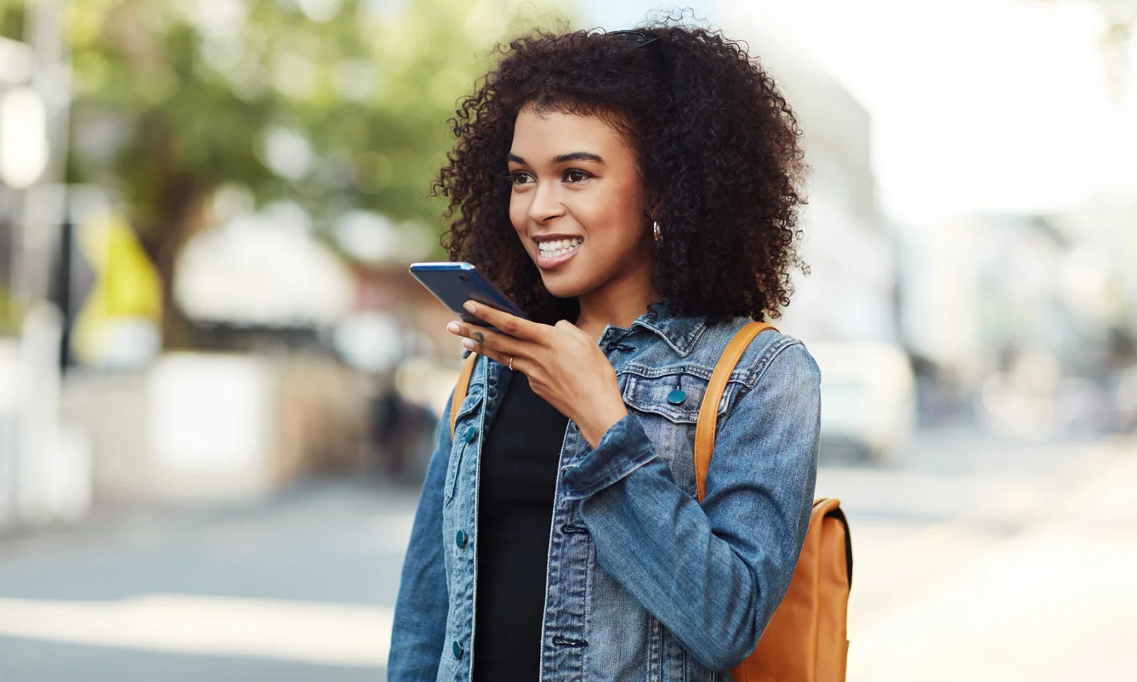 Eine junge Frau, die Sprachbefehle auf ihrem Smartphone verwendet und so einen verbesserten Kundenservice durch die Integration des Google Assistant darstellt.